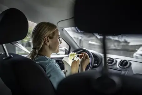 eating takeout noodles while driving